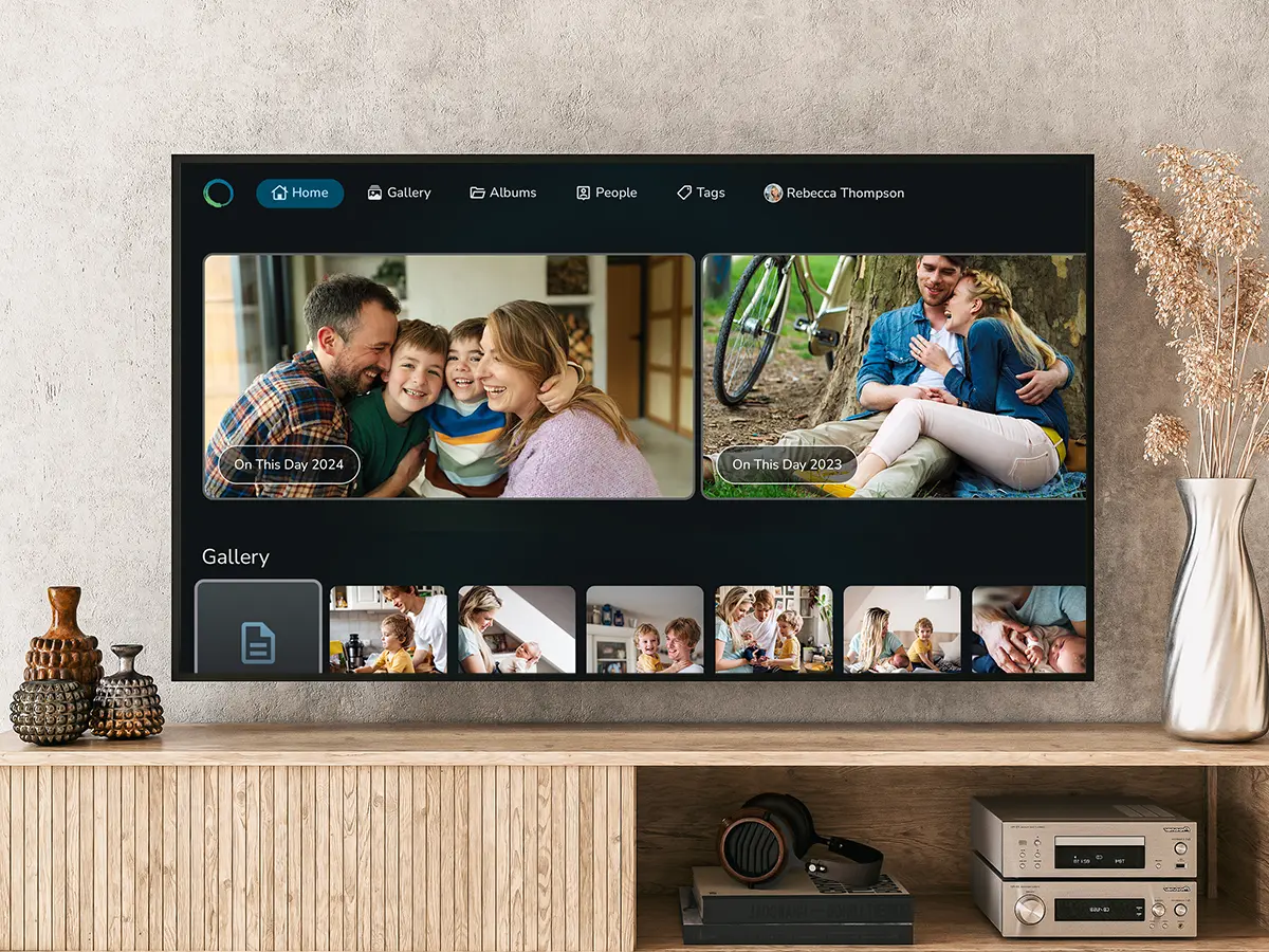 Wall-mounted television showing the FOREVER TV app's home screen with family memories